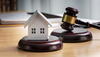 a model house sitting on top of a table next to a gavel